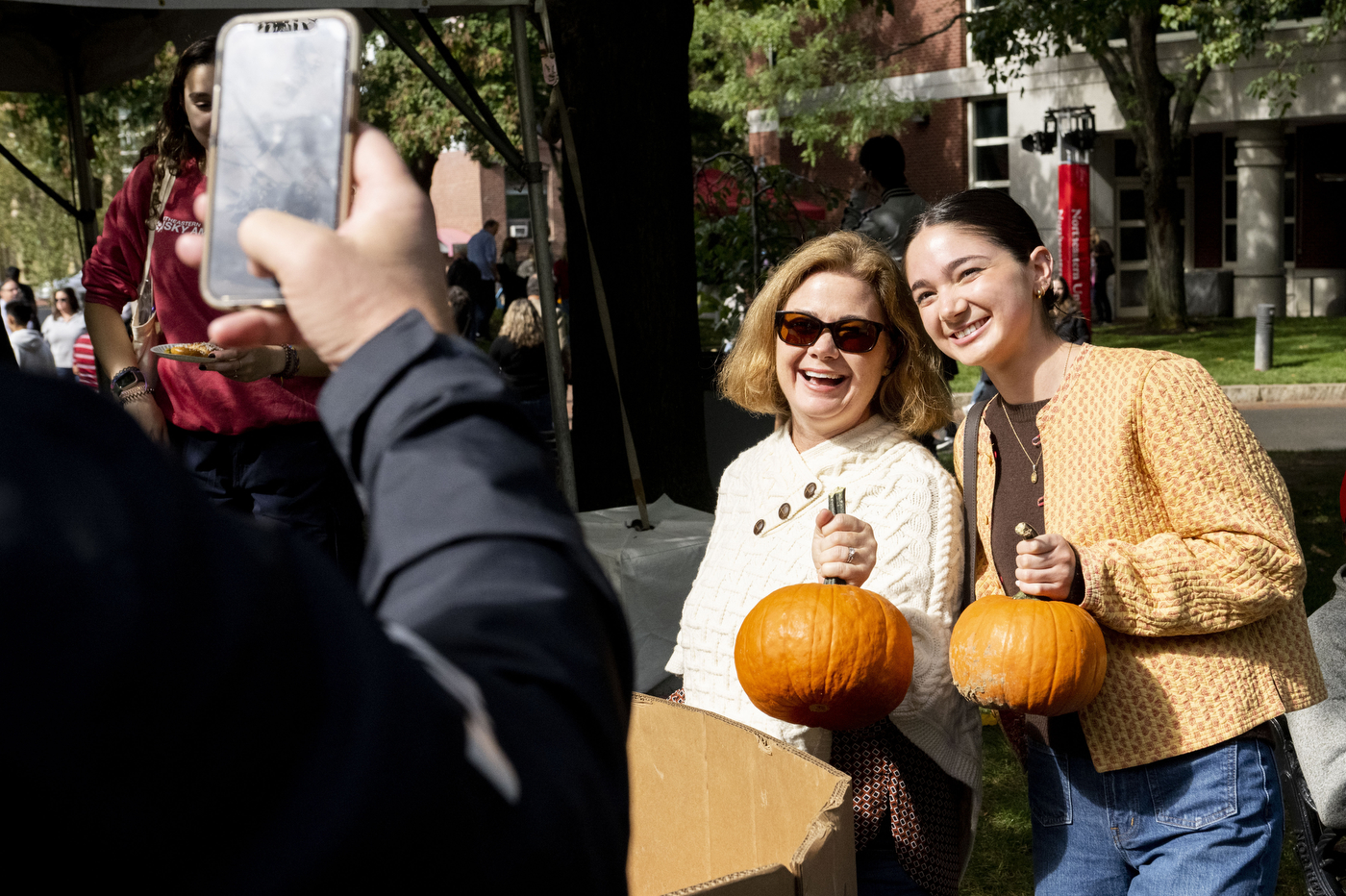 People posing with pumpkins at Family and Friends weekend.