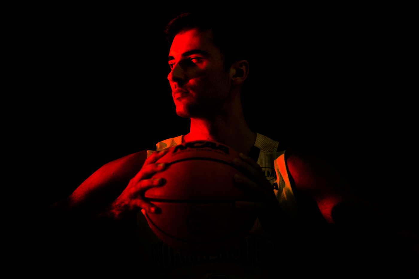 Headshot of Luka Sakota holding a basketball with a red overlay.