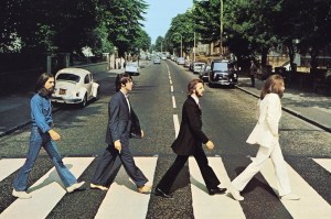 The Beatles 'Abbey Road' album cover featuring the four band members walking across the street on a crosswalk, known as the zebra crossing.
