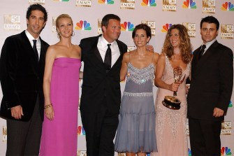 The cast of friends standing together posing for a group photo at the Emmy Awards.