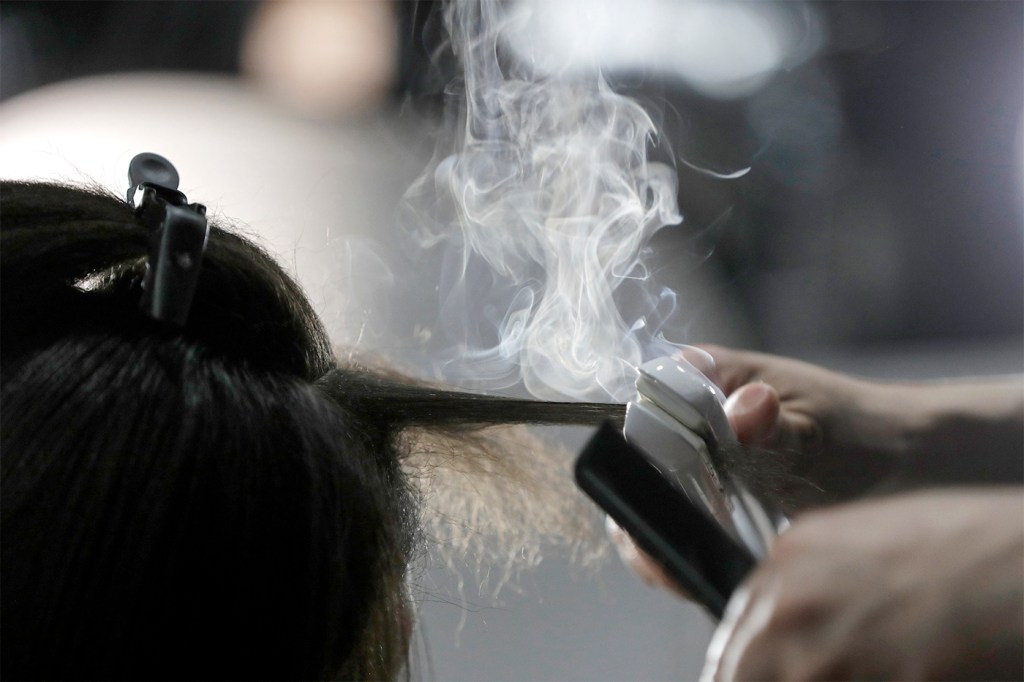 Steam rising from a person's hair as it's straightened.