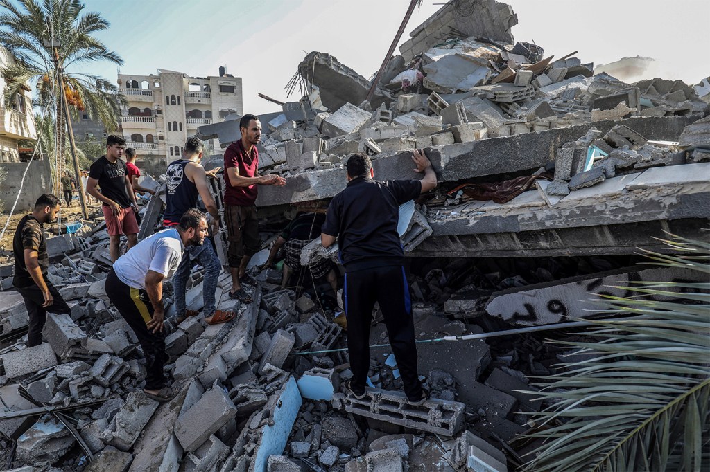 Palestinians searching for survivors among rubble.