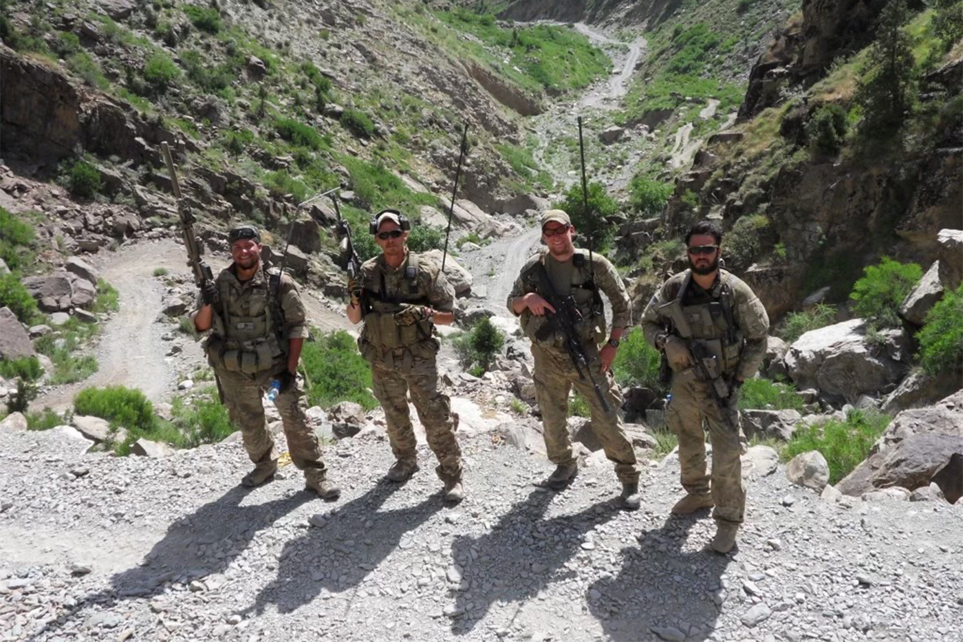Dennis Hernandez and three other military members standing outside on the edge of a canyon.