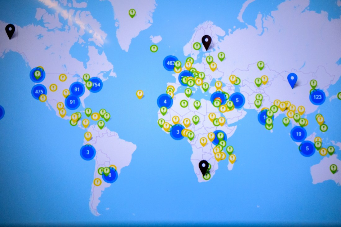 Screen displaying a map of the world with blue circles that have numbers in them, and then smaller green and yellow circles with exclamation points in specific locations.