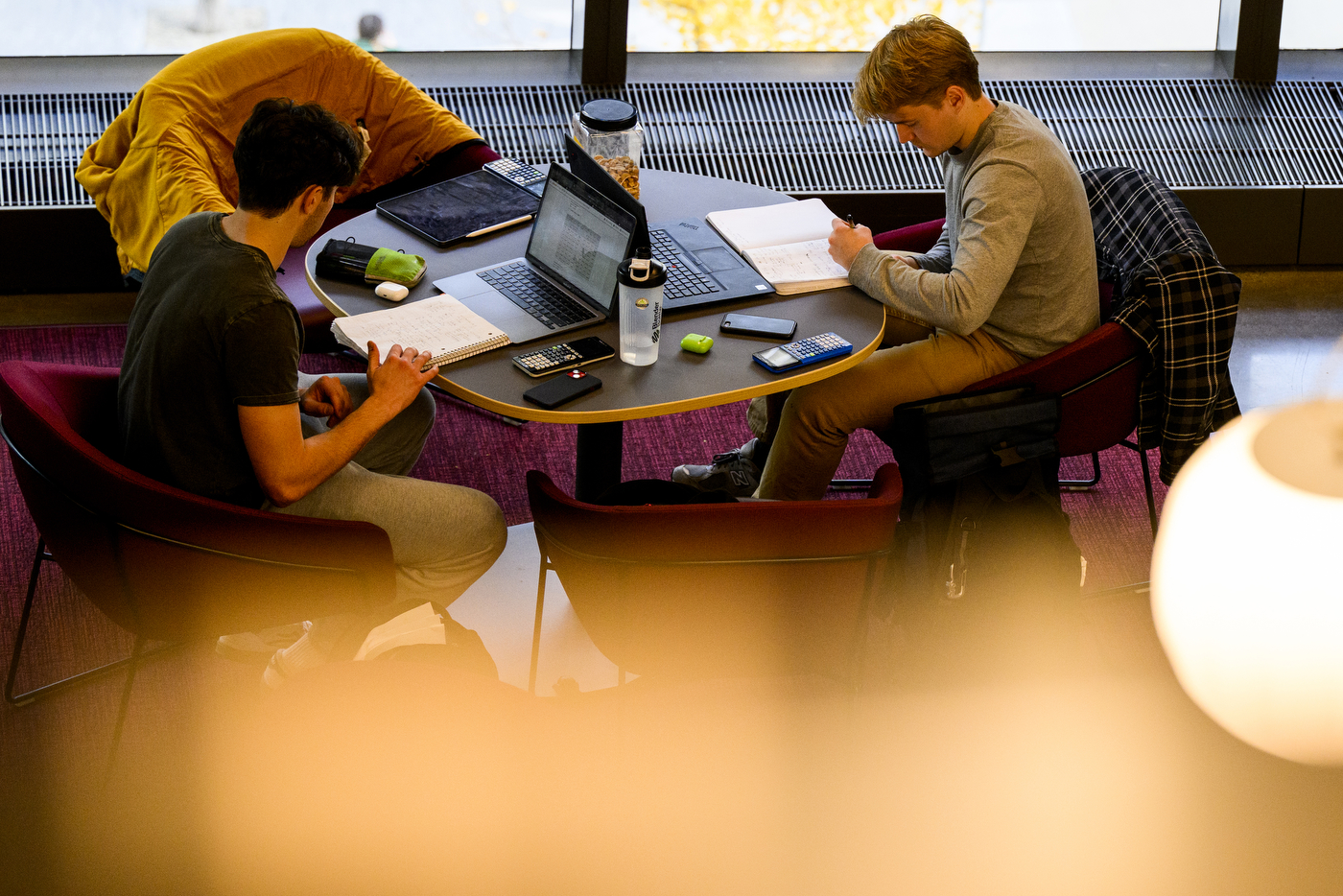 Two people study together at a round table. 