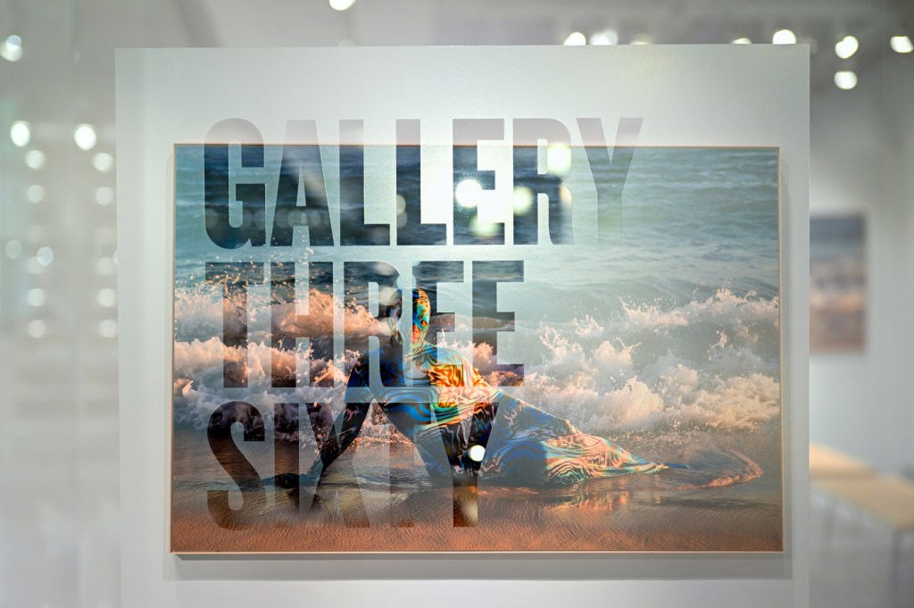Double exposure image of a piece from the Gallery 360 event seen through the glass wall of the exhibit.