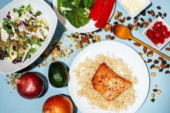 Plates of food from the Mediterranean diet, including salmon on rice and a salad.