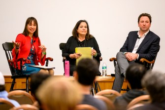 Mai’a Cross sitting with two panel speakers at the Crisis Conversation Series.