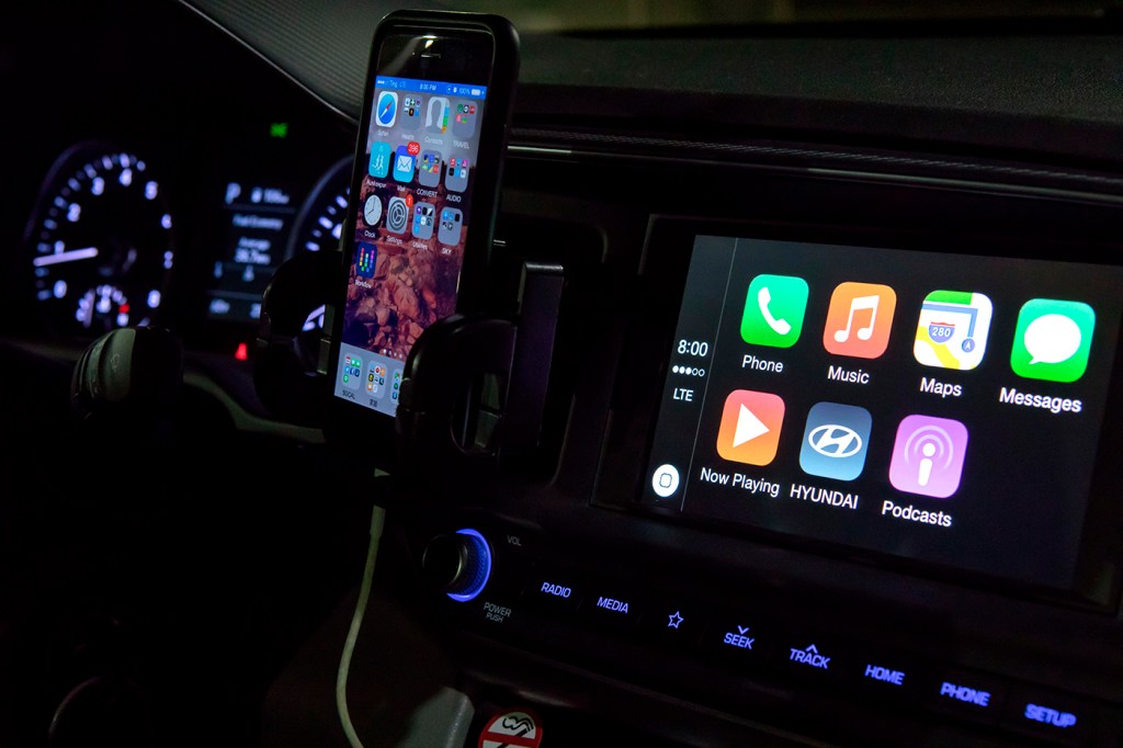 iPhone connected to a car with CarPlay displaying on the dashboard screen.