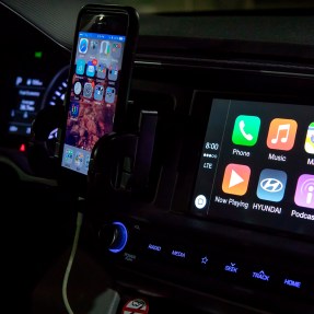 iPhone connected to a car with CarPlay displaying on the dashboard screen.