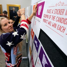 Molly Wheeler wearing a sweater with stars and stripes on it sets up an interactive board display.