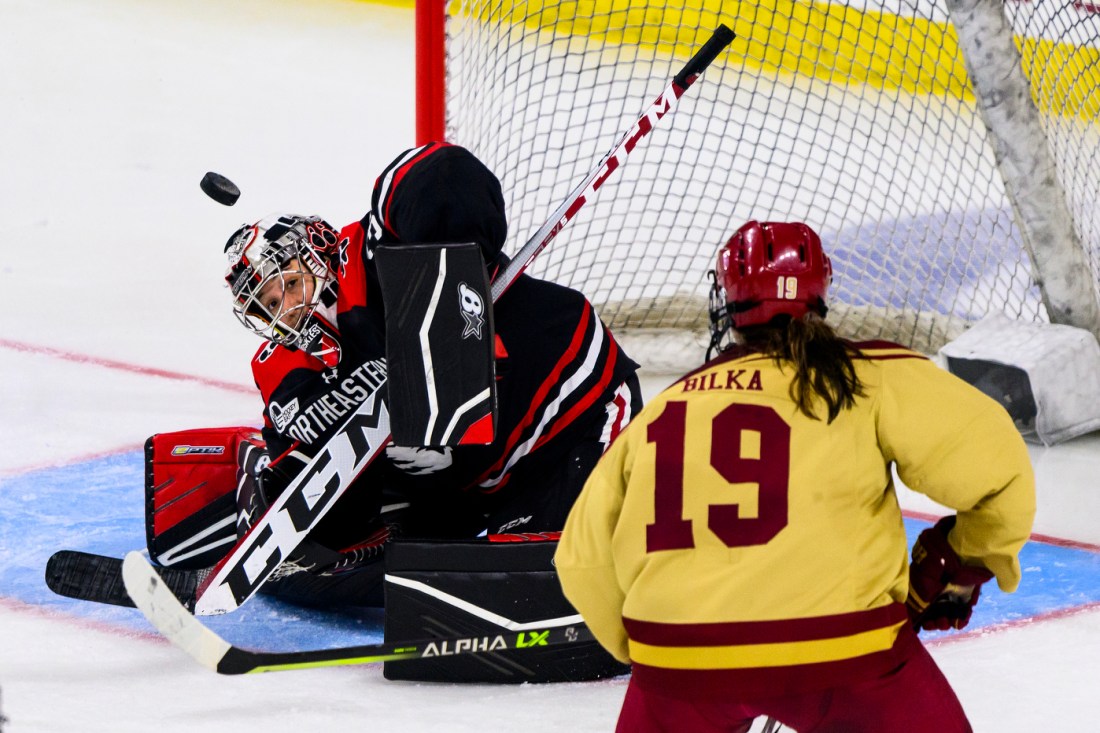 Northeastern womens hockey goalie saving a shot. 