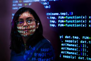Headshot of Srirupa Chakraborty with lines of code projected on to her face.