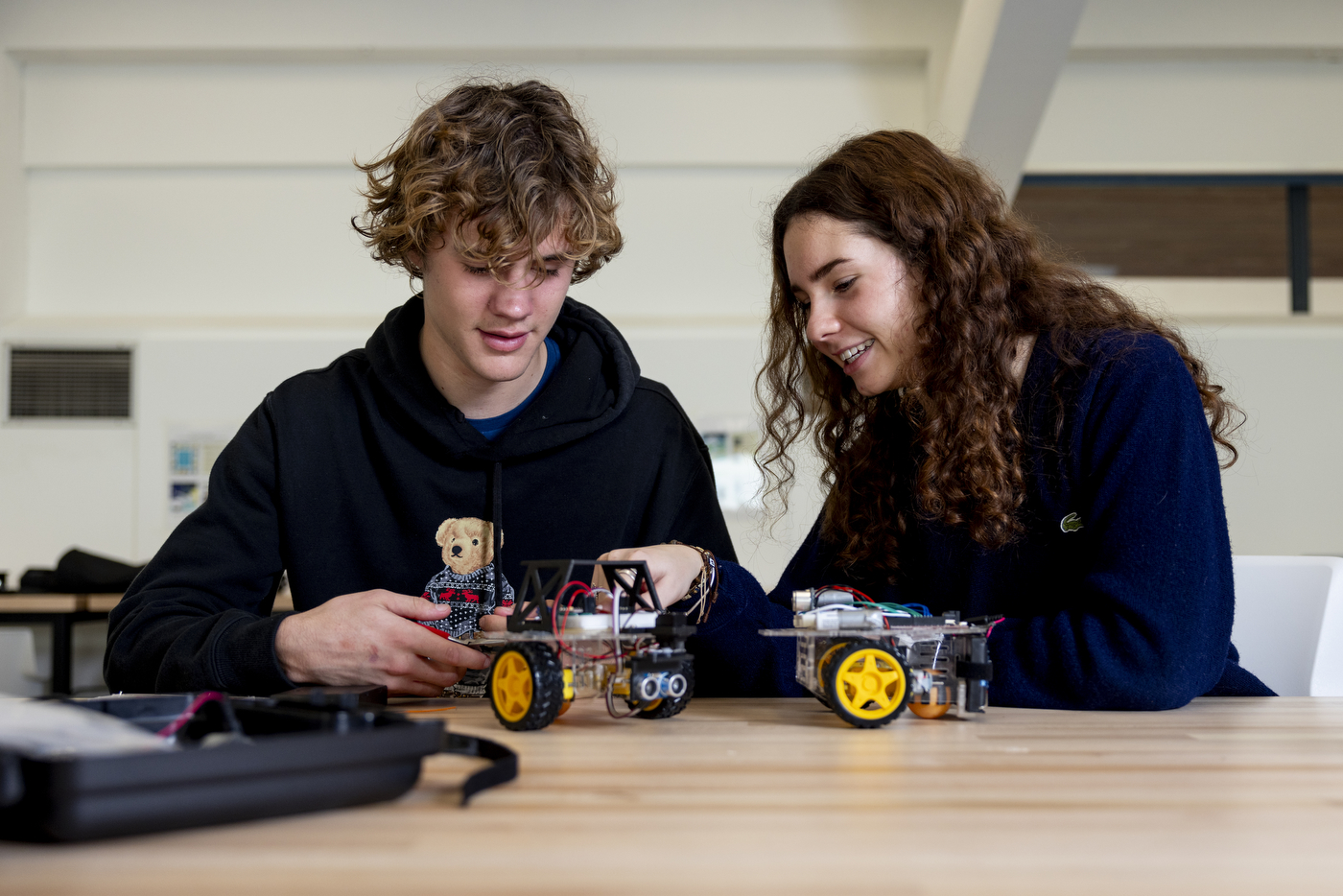 Students working on a self-driving robot at a table.