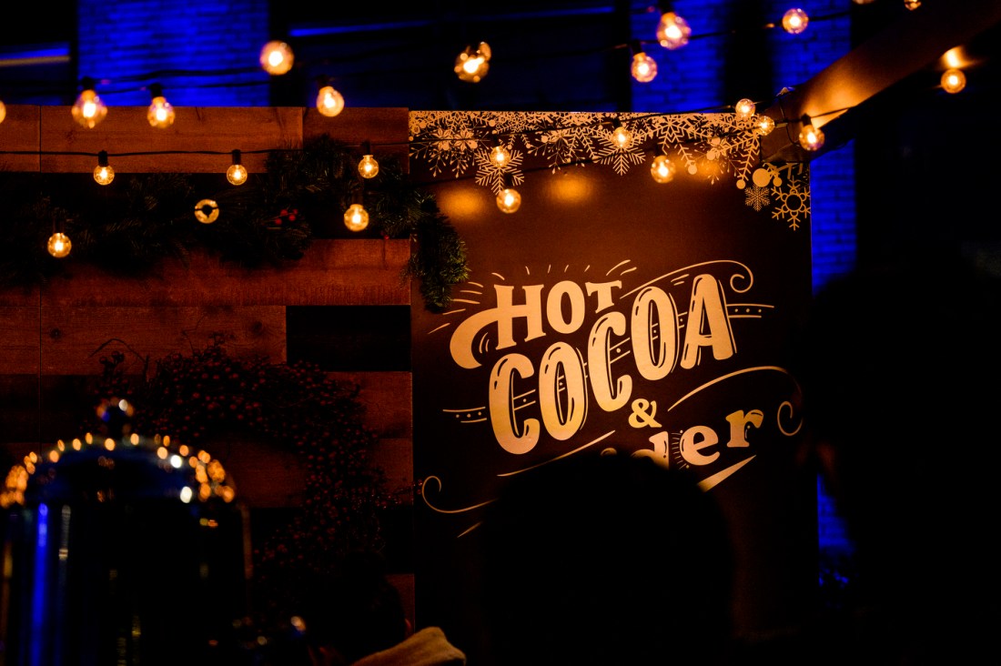 A sign with yellow text over a brown background: "Hot Cocoa & Cider."