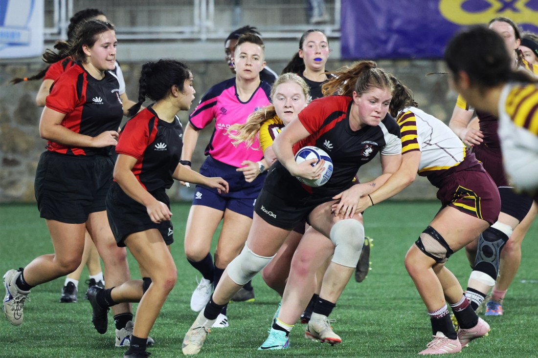 Northeastern womens rugby team playing on the field. 