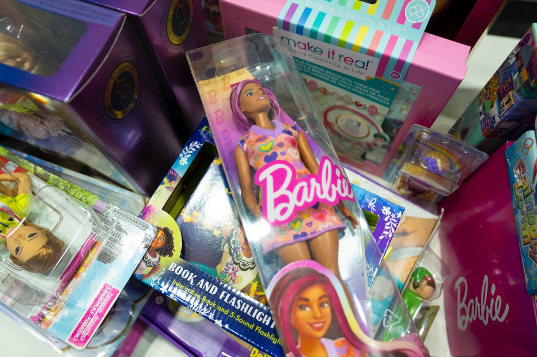 A Barbie Doll in its package on top of other toys. 