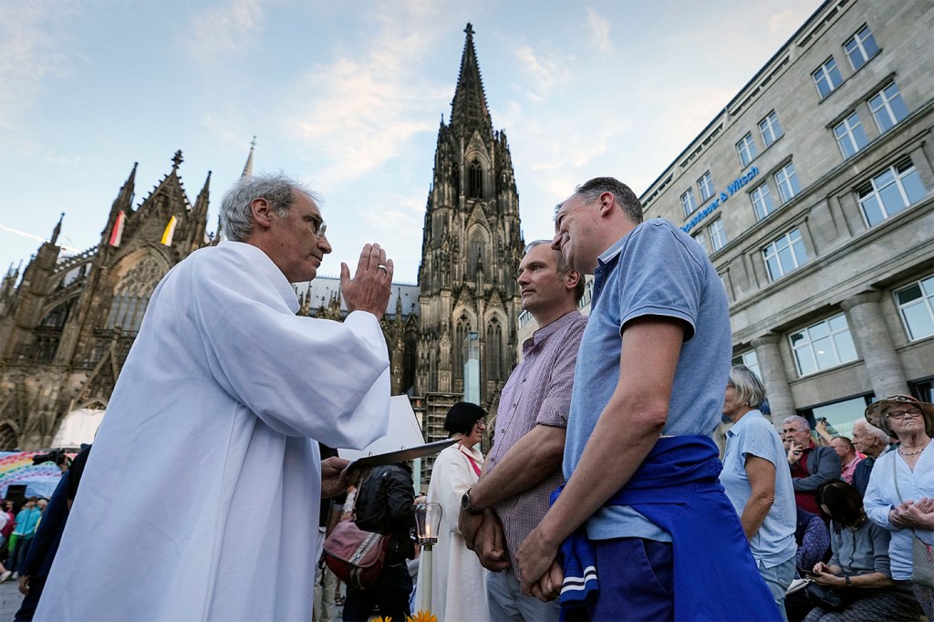 Same sex couple receiving a blessing by a priest in Germany.