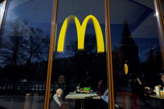 People eating in a McDonalds restaurant under the yellow M logo.