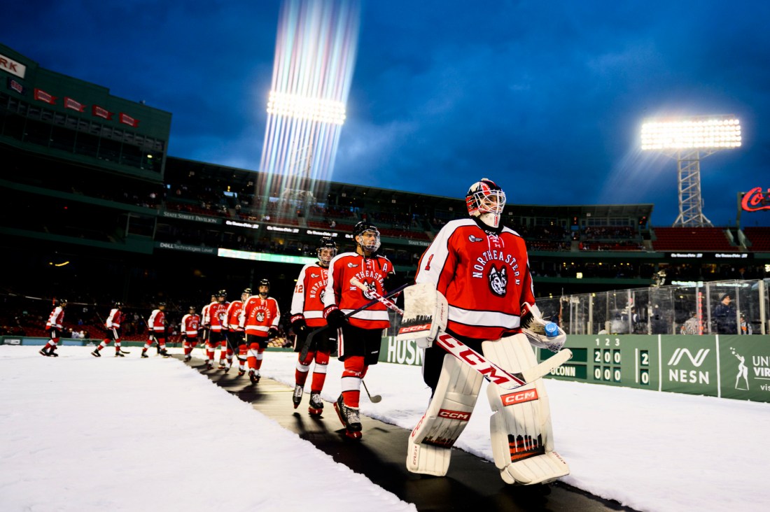 Northeastern mens hockey players walking on to the rink for Frozen Fenway in Fenway Park. 