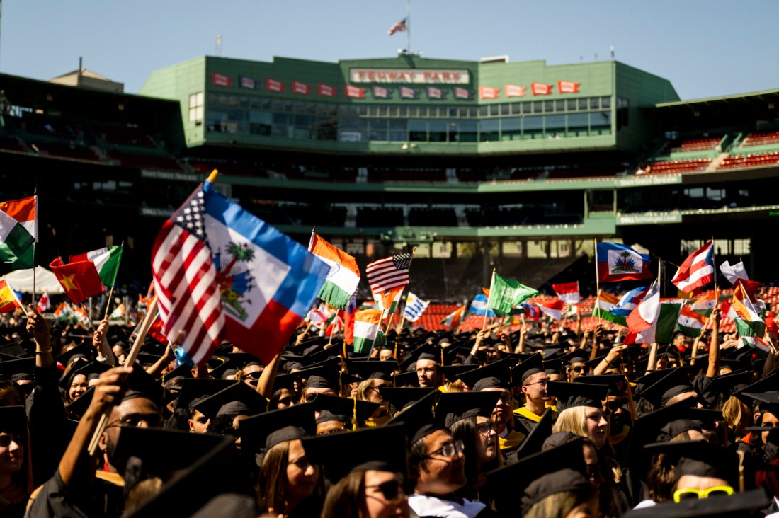 Northeastern graduates waving flags from the countries they are from in Fenway Park for Commencement. 