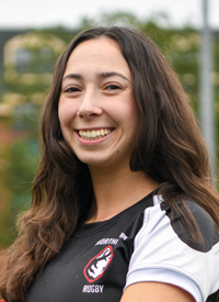 Headshot of Ally Johns outside in their Rugby uniform.