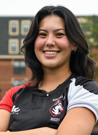 Headshot of Anastasia Hudak outside in their Rugby uniform.