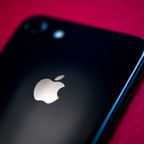 Black iPhone on red background.
