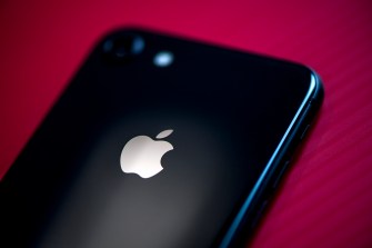 Black iPhone on red background.