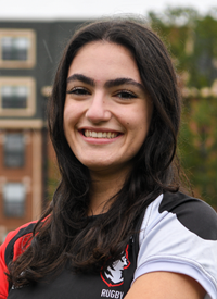 Headshot of Milia Chamas outside in their Rugby uniform.