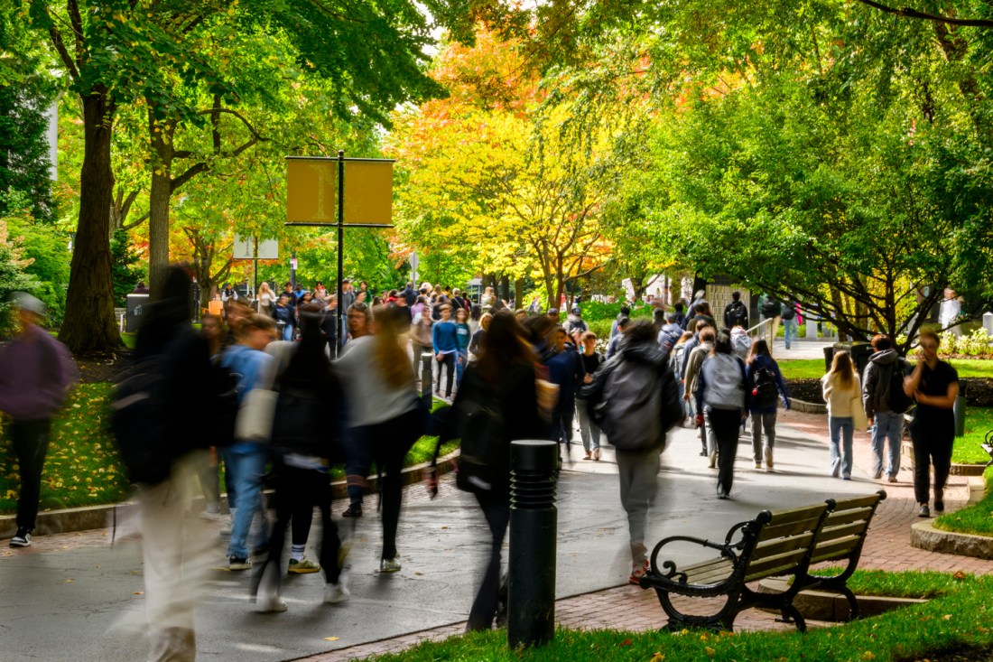 Students walking on the busy Northeastern University Boston campus on a summer day.