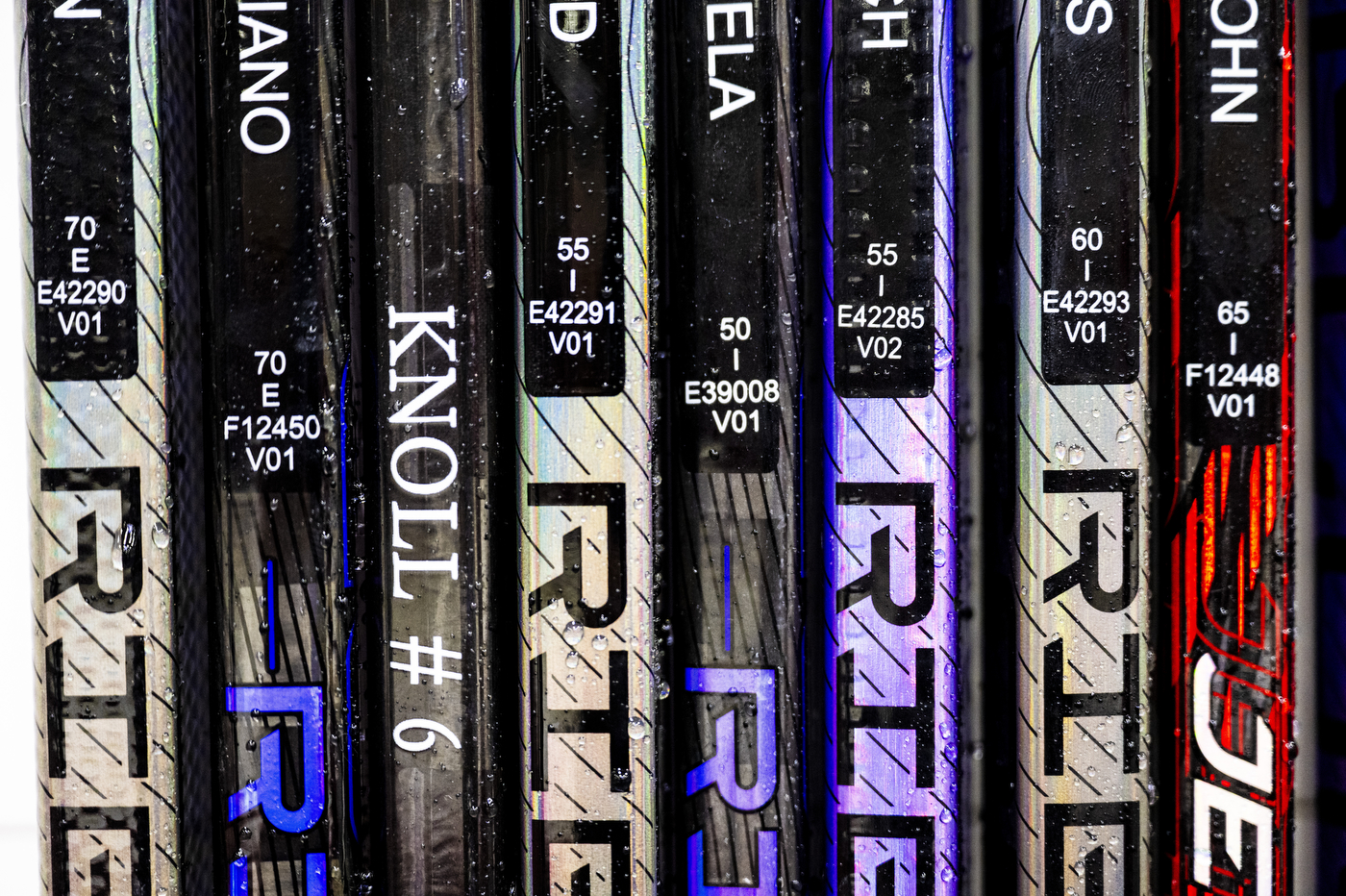 A rack of multi-colored hockey sticks.