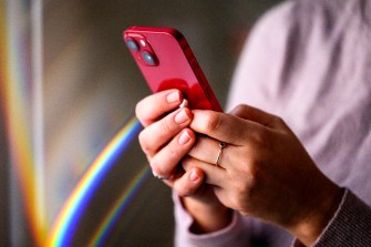 Person holding a red iPhone.