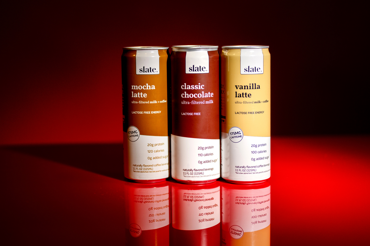 Three cans of Slate Milk, from left to right: Mocha Latte, Classic Chocolate, Vanilla Latte.