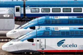Three Acela trains on tracks next to each other.