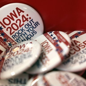 A stack of identical pins featuring a white background and red text that reads "Iowa 2024" for the state's early voting.