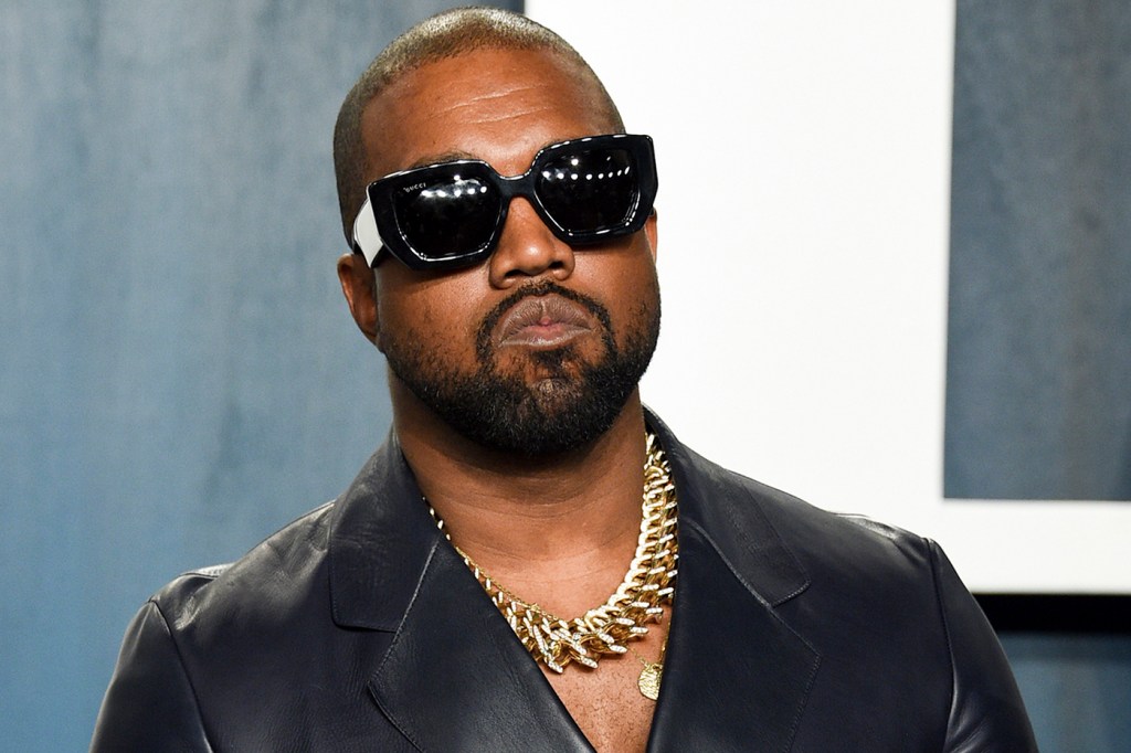 Kanye West at the Oscar Party wearing oversized sunglasses, a black shirt, and a chunky gold necklace.