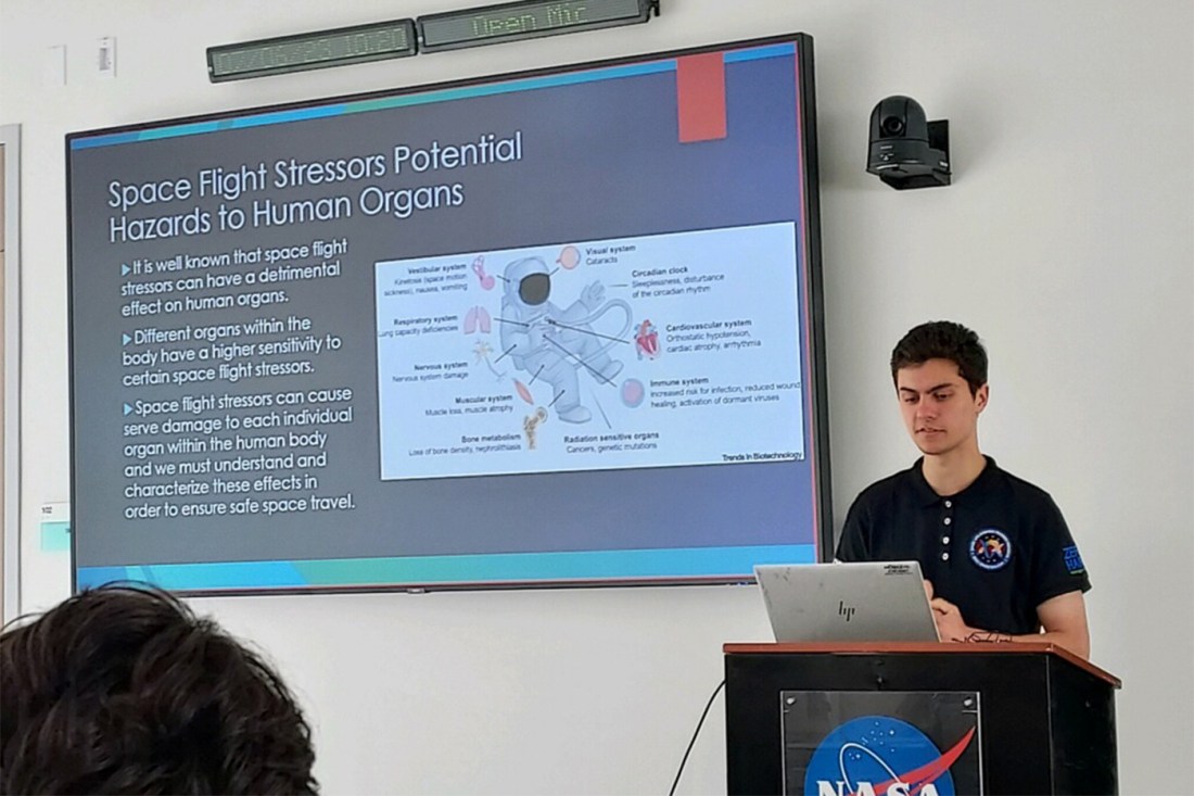 Dillon Nishigaya presenting a slide titled 'Space Flight Stressors Potential Hazards to Human Organs'