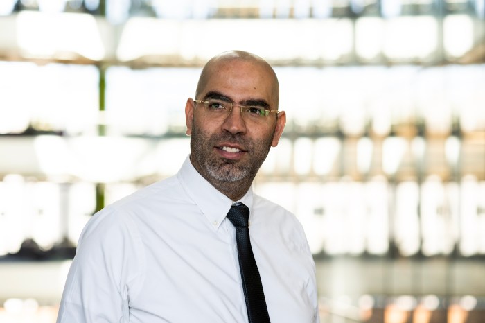 Saeed Amal, Northeastern research professor of bioengineering, smiling in a white shirt and dark tie inside the Interdisciplinary Science and Engineering Complex.