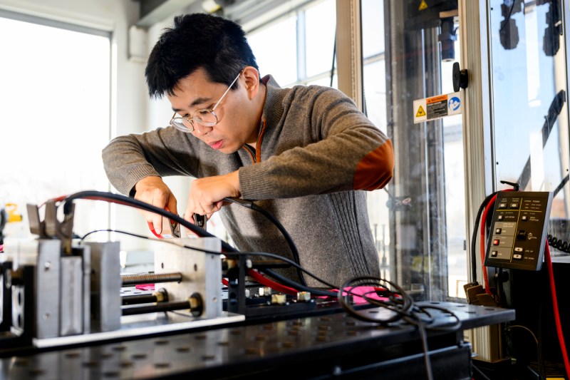 Juner Zhu working on an electric battery.