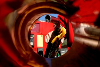 Person about to put a gas pump in their cars tank, viewed from inside the fuel tank.