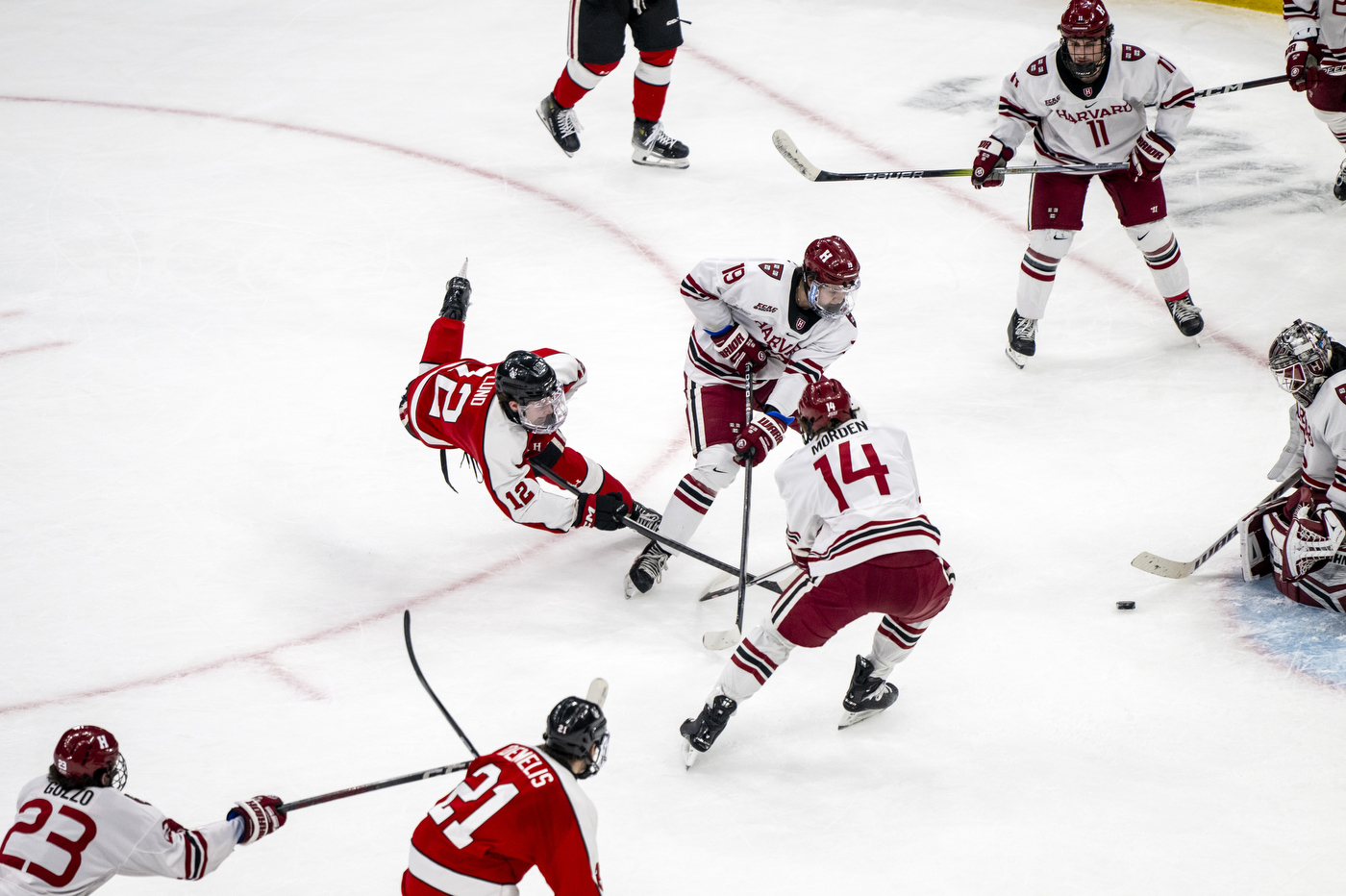 Northeastern hockey player shooting on Harvard's net.