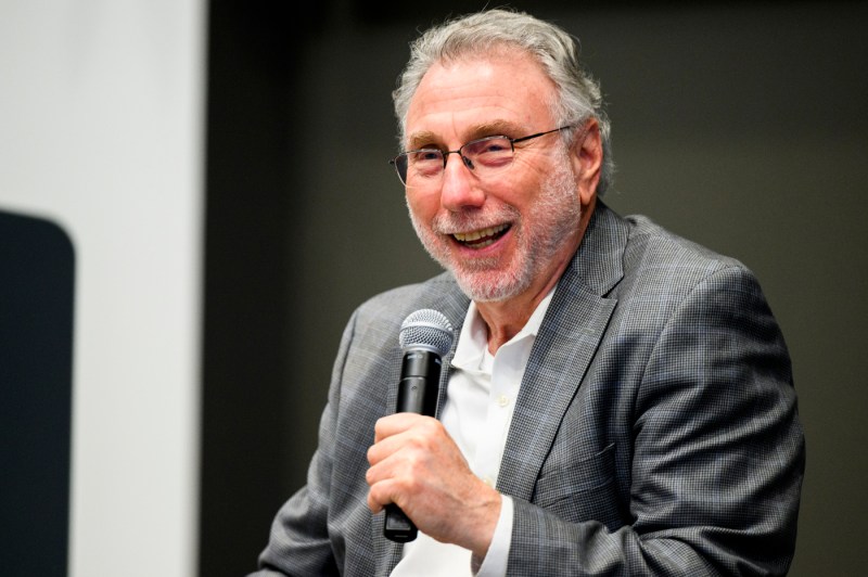 Marty Baron holding a microphone and laughing.