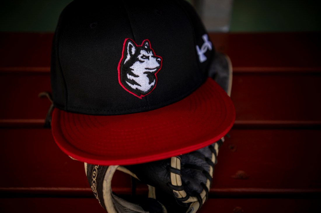 A black and red Northeastern men's baseball hat with an embroidered husky on the front.