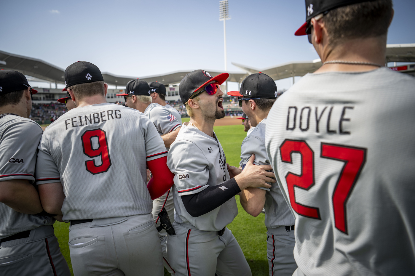 Seven baseball players wearing grey uniforms with red numbers stand together outside on a baseball field before facing off against the Boston Red Sox.