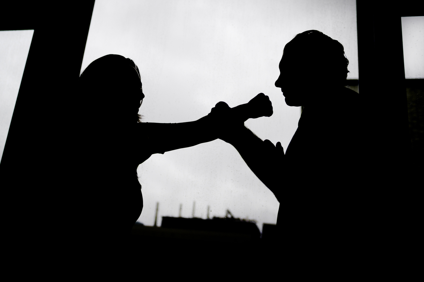 A silhouette of two people pretending to fight.