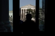 Silhouette of a person standing outside the Senate Chamber across from the Supreme Court.