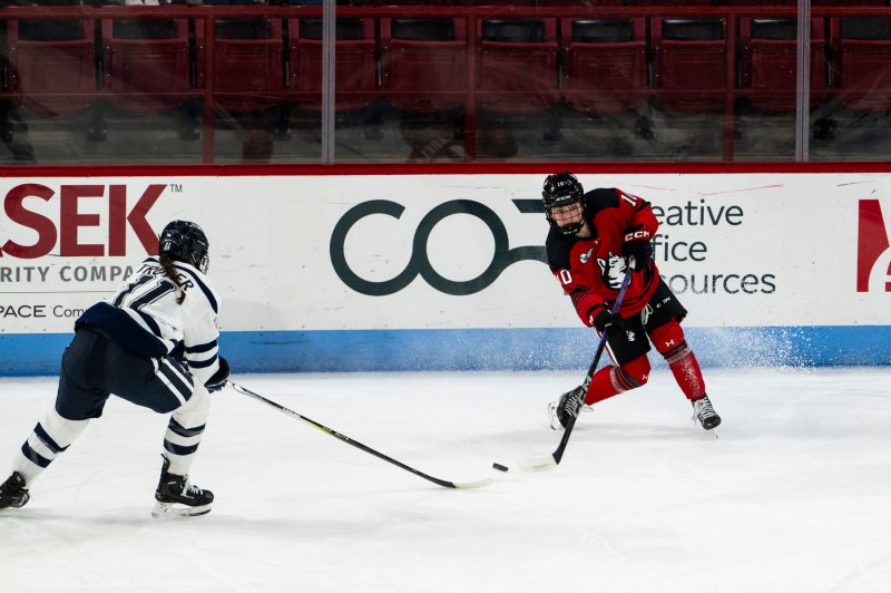 Northeastern womens hockey player taking a shot on goal. 