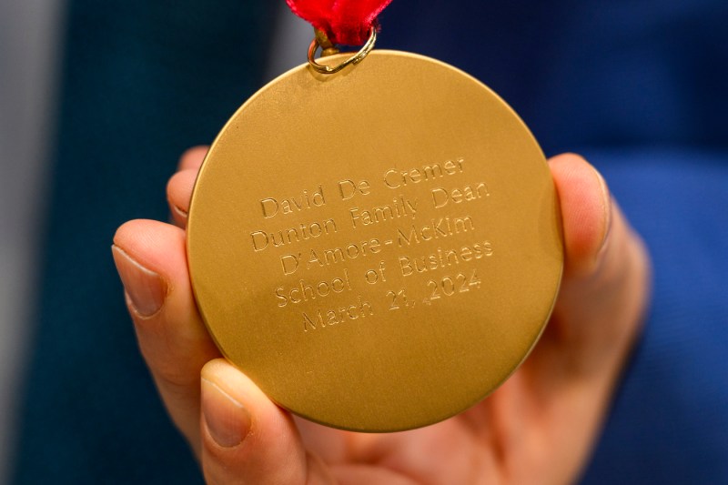 A gold medal with David De Cremer's name engraved.