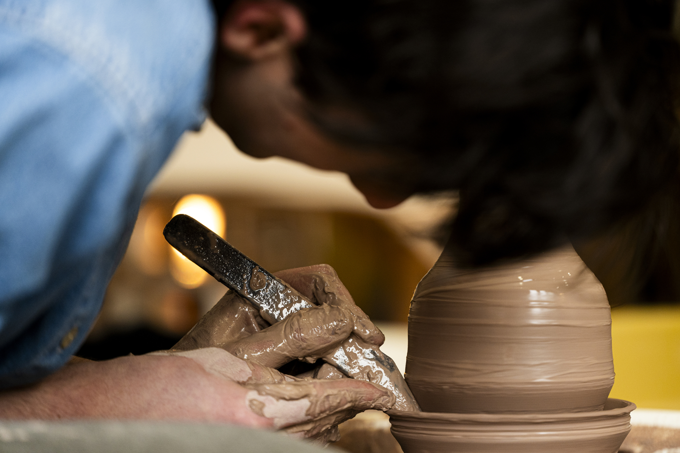 David Chatson shaping clay with a knife, creating a ridge.